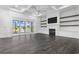 Spacious living room with fireplace, built-ins, dark-stained hardwood floors, and sliding glass doors to a pond view at 1531 Biltmore Dr., Myrtle Beach, SC 29579