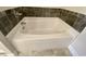 A close-up showcasing a bright white bath tub, complemented by dark tile and light-colored floors at 202 Rivers Edge Dr., Conway, SC 29526