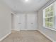 Neutral bedroom featuring carpeted floors, a window with blinds, and two bright white closets at 202 Rivers Edge Dr., Conway, SC 29526