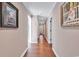 Long hallway with wood floors and framed artwork on the walls at 1202 Prince William Rd., North Myrtle Beach, SC 29582