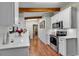 Long kitchen with white cabinets, stainless steel appliances, and wood floors at 1202 Prince William Rd., North Myrtle Beach, SC 29582