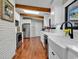 White kitchen with stainless steel appliances and a brick accent wall at 1202 Prince William Rd., North Myrtle Beach, SC 29582