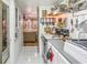 Small kitchen with white cabinets, vintage sink, and open shelving at 7509 N Ocean Blvd. # 104, Myrtle Beach, SC 29572