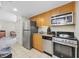 Modern kitchen with stainless steel appliances and wooden cabinets, next to an open door at 201 S Ocean Blvd. # 1005, Myrtle Beach, SC 29577