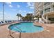 A refreshing outdoor swimming pool area with palm trees and lounge chairs for relaxation at 201 S Ocean Blvd. # 1005, Myrtle Beach, SC 29577