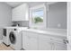 Bright laundry room featuring front loading washer and dryer, ample cabinet space and a convenient utility sink at 1533 Biltmore Dr., Myrtle Beach, SC 29579
