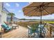 Enjoy beautiful views from this outdoor deck furnished with chairs, a table, and umbrella at 4524 Landing Rd., Little River, SC 29566