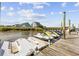Jet skis docked on a pier with waterfront homes in the background, a perfect spot for water sports enthusiasts at 4524 Landing Rd., Little River, SC 29566