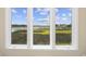 Beautiful view of a marsh and boats through a bright, white framed, divided lite window at 4524 Landing Rd., Little River, SC 29566