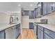 Modern kitchen featuring navy cabinets, quartz countertops, stainless steel appliances, and wood-look flooring at 626 Castle Ct., Myrtle Beach, SC 29579