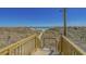 Wooden stairs lead to a beautiful beach, with blue skies, and natural dunes at 4719 S Ocean Blvd. # 209, North Myrtle Beach, SC 29582