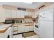 Galley kitchen with white cabinets, microwave, oven, and washer at 4719 S Ocean Blvd. # 209, North Myrtle Beach, SC 29582