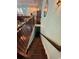 Staircase leading to lower level with dark wood stairs and wooden railing with rod iron accents at 590 Collins Ave., Murrells Inlet, SC 29576