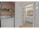 Laundry room with washer, dryer, storage shelves, and entrance to bathroom with vanity at 601 Hillside Dr. N # 2903, North Myrtle Beach, SC 29582