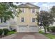 Two-story yellow house with double garage and paved driveway at 1335 Hidden Harbor Rd., Myrtle Beach, SC 29577