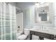 Cozy bathroom features a shower-tub combo, decorative mirror and beach-themed art at 1907 S Waccamaw Dr., Garden City Beach, SC 29576