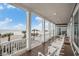 Covered porch with rocking chairs overlooking the beach with palm trees and blue skies at 1907 S Waccamaw Dr., Garden City Beach, SC 29576