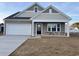 Two-story house with beige and brown siding, white garage door, and landscaping at 714 Night Lotus Dr., Calabash, NC 28467