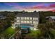 Aerial view of luxurious three-story home with a pool, manicured lawn and scenic sunset at 8000 Beach Dr., Myrtle Beach, SC 29572
