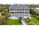 Aerial view of beautiful three-story home with a pool and manicured lawn at 8000 Beach Dr., Myrtle Beach, SC 29572