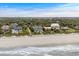 Aerial view showcases the stunning oceanfront location of this home with lush landscaping and private beach access at 8000 Beach Dr., Myrtle Beach, SC 29572