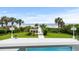 Beachside backyard with manicured lawn, palm trees, outdoor lights, and path to the beach at 8000 Beach Dr., Myrtle Beach, SC 29572