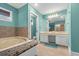 Bathroom features a tiled tub and vanity with storage and a wide mirror at 8000 Beach Dr., Myrtle Beach, SC 29572