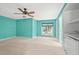 Bedroom with turquoise walls features a ceiling fan and a window overlooking outdoor greenery at 8000 Beach Dr., Myrtle Beach, SC 29572