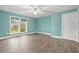 Bedroom with turquoise walls features a ceiling fan and a window overlooking outdoor greenery at 8000 Beach Dr., Myrtle Beach, SC 29572