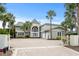 Stunning two-story home features a brick driveway, towering palm trees, and a grand entrance at 8000 Beach Dr., Myrtle Beach, SC 29572