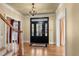 Welcoming foyer showcasing hardwood floors, chandelier, and a glass-paneled front door allowing natural light at 4569 Carriage Run Circle, Murrells Inlet, SC 29576