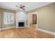 Cozy living room with a classic brick fireplace, hardwood floors, and ample natural light from the window at 4569 Carriage Run Circle, Murrells Inlet, SC 29576