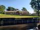 Water view of back of brick home with covered porch on a manicured green lawn at 5864 Crestwood Dr., Myrtle Beach, SC 29578
