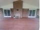 Covered back porch with painted wood flooring, brick and white accents, seating, and sliding glass doors at 5864 Crestwood Dr., Myrtle Beach, SC 29578