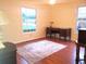 Bright bedroom with wood floors, area rug, desk, and natural light from two large windows at 5864 Crestwood Dr., Myrtle Beach, SC 29578