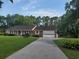 Charming brick ranch with well-maintained lawn and attached garage in a serene, tree-lined setting at 5864 Crestwood Dr., Myrtle Beach, SC 29578