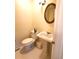 Powder room featuring a pedestal sink, round mirror, and white tile flooring, offering essential convenience at 5864 Crestwood Dr., Myrtle Beach, SC 29578