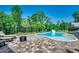 Relaxing kidney-shaped pool with a slide, surrounded by a brick patio and lounge chairs at 1055 Academy Dr., Conway, SC 29526