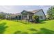 Landscaped backyard with a covered patio and a black metal fence at 1926 Bluff Dr., Myrtle Beach, SC 29577