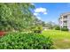 Scenic backyard showcasing a well-maintained lawn, pond, and the building's architecture at 4709 Wild Iris Dr. # 104, Myrtle Beach, SC 29577