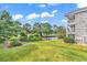 Picturesque backyard with a pond, a golf course, and the building's facade, offering a tranquil setting at 4709 Wild Iris Dr. # 104, Myrtle Beach, SC 29577