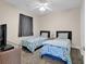 Comfortable bedroom featuring two twin beds with coastal themed linens and a ceiling fan at 4709 Wild Iris Dr. # 104, Myrtle Beach, SC 29577