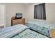 Twin beds with ocean-themed bedding and a wicker dresser with a TV in this cozy bedroom at 4709 Wild Iris Dr. # 104, Myrtle Beach, SC 29577