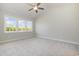 Bright bedroom with a ceiling fan and three windows providing natural light and neighborhood views at 112 Infinity Ln., Loris, SC 29569