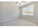 Cozy bedroom with neutral carpeting, ceiling fan, and a large window for natural light at 112 Infinity Ln., Loris, SC 29569