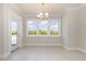 Bright dining room featuring a chandelier, a glass-paneled door, and large windows with natural light at 112 Infinity Ln., Loris, SC 29569