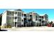 Apartment building with light green exterior, balconies, and ample parking at 35 Delray Dr. # 1-E, Murrells Inlet, SC 29576