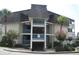 Two-story condo building with light-colored siding, balconies, and landscaping at 5601 Ocean Blvd. N # 202 A, Myrtle Beach, SC 29577