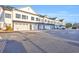 Row of new townhomes with white siding, black shutters, and individual garages in a large parking lot at Lot 40 Lineback Pl. # 40, Longs, SC 29568