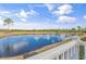 Back deck view of a pond surrounded by trees under a partially cloudy blue sky at Lot 40 Lineback Pl. # 40, Longs, SC 29568